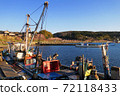 A row of cherry blossom trees along the sea seen from a small fishing port 72118433