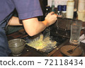 A part-time clerk who makes monjayaki on an iron plate at a customer table 72118434