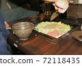 A part-time clerk who makes monjayaki on an iron plate at a customer table 72118435