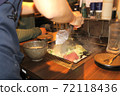 A part-time clerk who makes monjayaki on an iron plate at a customer table 72118436