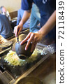 A part-time clerk who makes monjayaki on an iron plate at a customer table 72118439