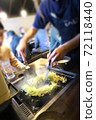 A part-time clerk who makes monjayaki on an iron plate at a customer table 72118440