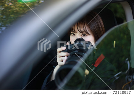 Woman taking pictures from inside the car 72118937