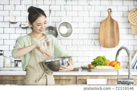 在廚房裡做飯一個微笑的女人 72119146