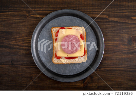 Sandwich on a metal plate. Healthy and unhealthy food concept. Dark wooden background 72119386