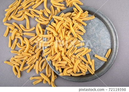 Strozzapreti, Italian pasta in metal plate on a gray table Strozzapreti, Italian pasta in metal plate on a gray table 72119398