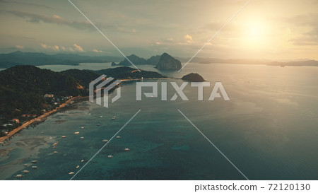 Sunset at sea bay: boats, yachts at water. Seascape at ocean coast with sand beach, green palm tree Sunset at sea bay: boats, yachts at water. Seascape at ocean coast with sand beach, green palm tree 72120130