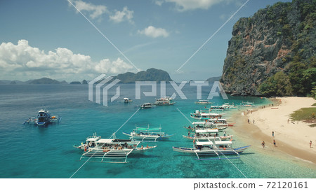 Aerial view of passenger boats with tourists rest at sea sand beach of Palawan island, Philippines Aerial view of passenger boats with tourists rest at sea sand beach of Palawan island, Philippines 72120161