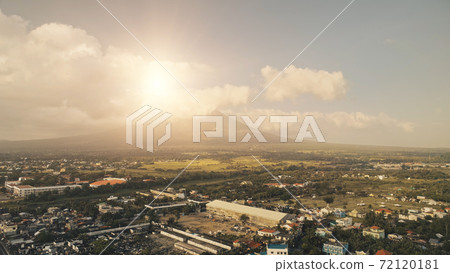 Sun shine over Mayon volcano erupt at Legazpi cityscape aerial. Philippines tourist landmark 72120181