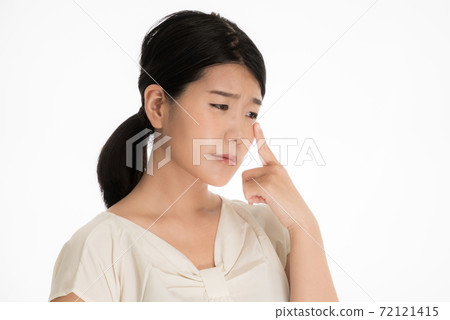 A woman who holds her eyes and suffers from a medical condition 72121415