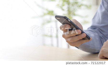 A man operating a smartphone A man operating a smartphone 72122017