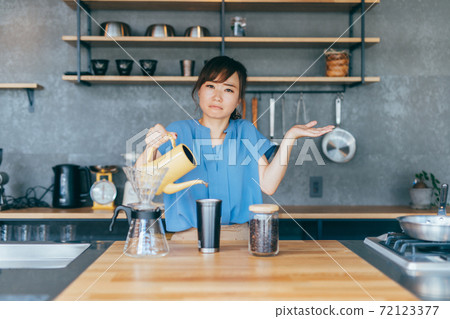 Woman making coffee in the kitchen 72123377