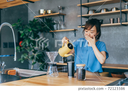 Woman making coffee in the kitchen 72123386
