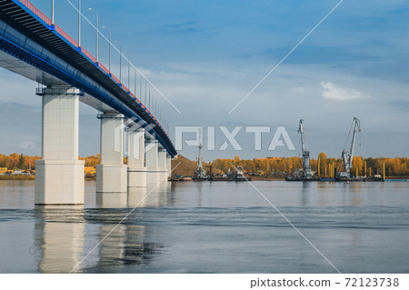 Sunset river gateway bridge blue sky and clouds. Autumn River bridge view. Cargo ships loading in cargo terminal on background 72123738