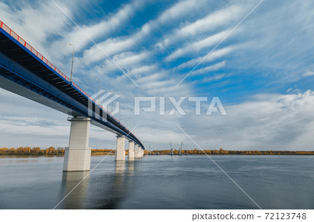 River gateway bridge blue sky and clouds. Autumn River bridge view. Cargo ships loading in cargo terminal on background River gateway bridge blue sky and clouds. Autumn River bridge view. Cargo ships loading in cargo terminal on background 72123748
