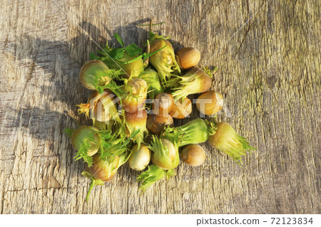 Green hazelnuts on the wooden table, autumn harvest of nuts 72123834
