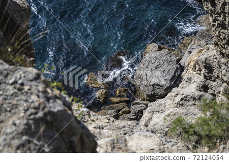 Waves crash against the rocks. Top view of the sea 72124054