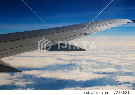 Seeing the plane's wing and the outer view from the window. 72126815