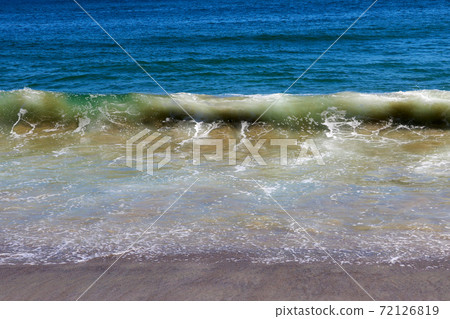 A beautiful wave of the Pacific Ocean rolls on the beach. A beautiful wave of the Pacific Ocean rolls on the beach. 72126819