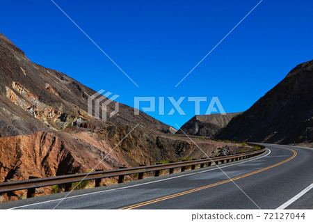 Classic panorama view of an endless straight road running through the barren scenery of the American Southwest. 72127044