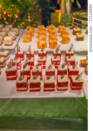 Well-decorated red velvet cake and choux pastry in a party Well-decorated red velvet cake and choux pastry in a party 72128984