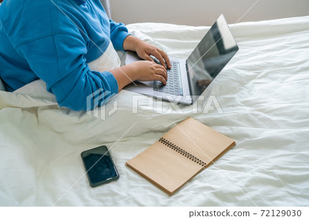 Side view of young female hand typing on laptop Side view of young female hand typing on laptop 72129030