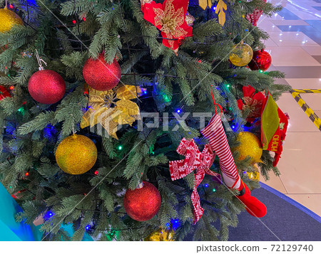 Lovely decoration with shiny baubles on Christmas tree 72129740