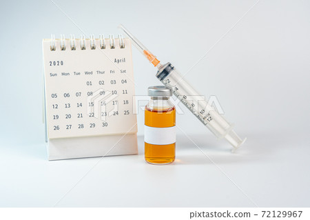 Blank label vaccine bottle and 2020 calendar on white background 72129967