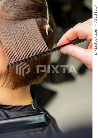 Hairdresser straightening short brown hair 72131517