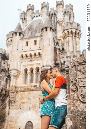 Young couple in front of a medieval castle Young couple in front of a medieval castle 72131559
