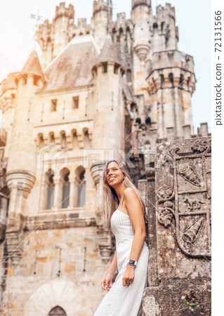 Young woman in front of a medieval castle Young woman in front of a medieval castle 72131566