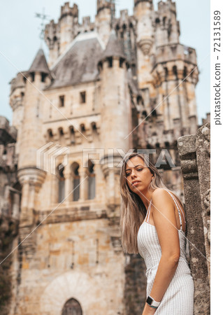 Young woman in front of a medieval castle Young woman in front of a medieval castle 72131589