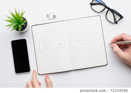 Person makes notes at the table in the diary copy space 72134506