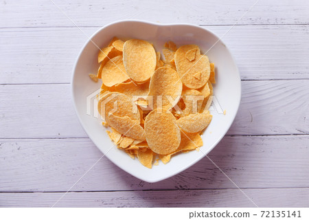 Bowl with tasty potato chips on wooden background . Bowl with tasty potato chips on wooden background . 72135141