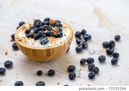 Healthy breakfast with blueberries in white yoghurt and crunchy cereal. Healthy breakfast with blueberries in white yoghurt and crunchy cereal. 72135184
