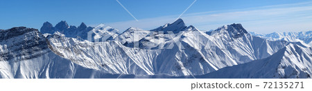 Large panorama of snowy mountains and blue sky Large panorama of snowy mountains and blue sky 72135271