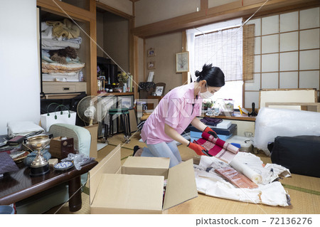 Workers cleaning up cluttered rooms 72136276