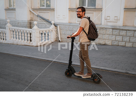fun driving electric scooter through the city. fun driving electric scooter through the city. 72138239