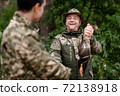Happy Hunter Man Shows Fetched Wild Duck to Son. 72138918