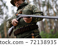 Experienced Hunter Charges Shotgun in Forest. 72138935
