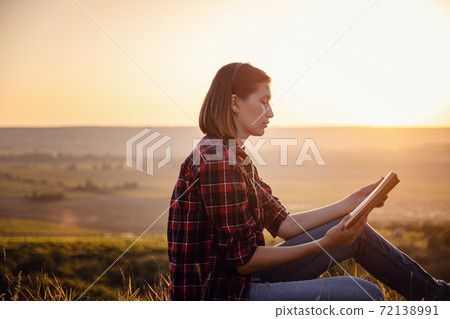 beautiful woman writing into her diary, in the park 72138991