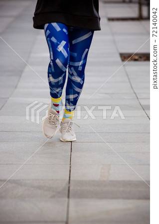 Young sport woman in bright sportswear doing morning running outdoors. 72140042