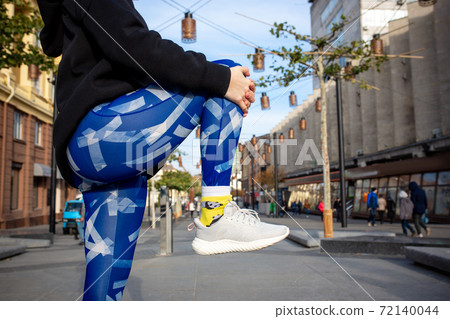 Young sport woman in fashion sportswear doing fitness exercise outdoors. 72140044