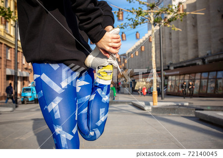 Young sport woman in fashion sportswear doing fitness exercise outdoors. 72140045