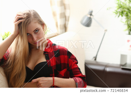 young blond woman sit on sofa in room early morning young blond woman sit on sofa in room early morning 72140834