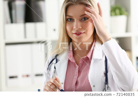 Beautiful smiling female doctor sit at workplace Beautiful smiling female doctor sit at workplace 72140835