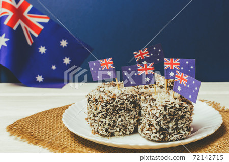 Iconic traditional Australian party food, Lamington cakes on a red, white and blue background. Iconic traditional Australian party food, Lamington cakes on a red, white and blue background. 72142715