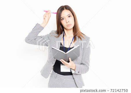 Business woman writing notes in a notebook Business woman writing notes in a notebook 72142750