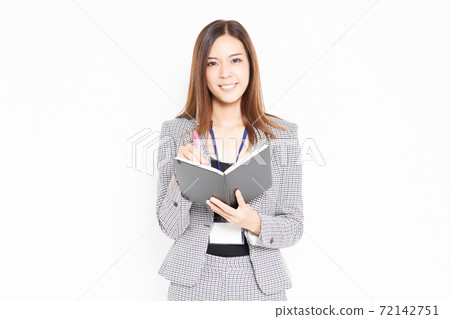 Business woman writing notes in a notebook 72142751