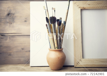 canvas, paintbrush on wooden background canvas, paintbrush on wooden background 72142901